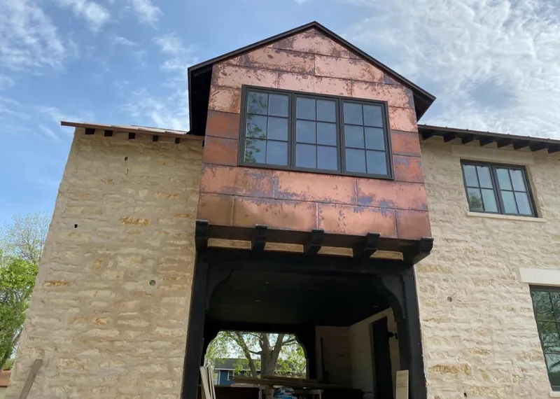 Copper metal panel facade on a stone building for Metal Roof Coating in Verdigris